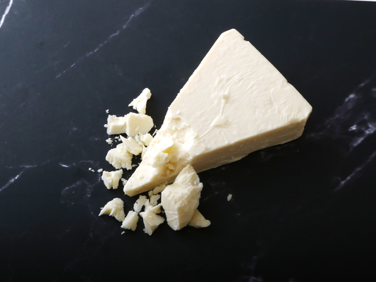 an 8 ounce piece of Stella Fontinella, on a black marble background, slightly crumbled to show texture